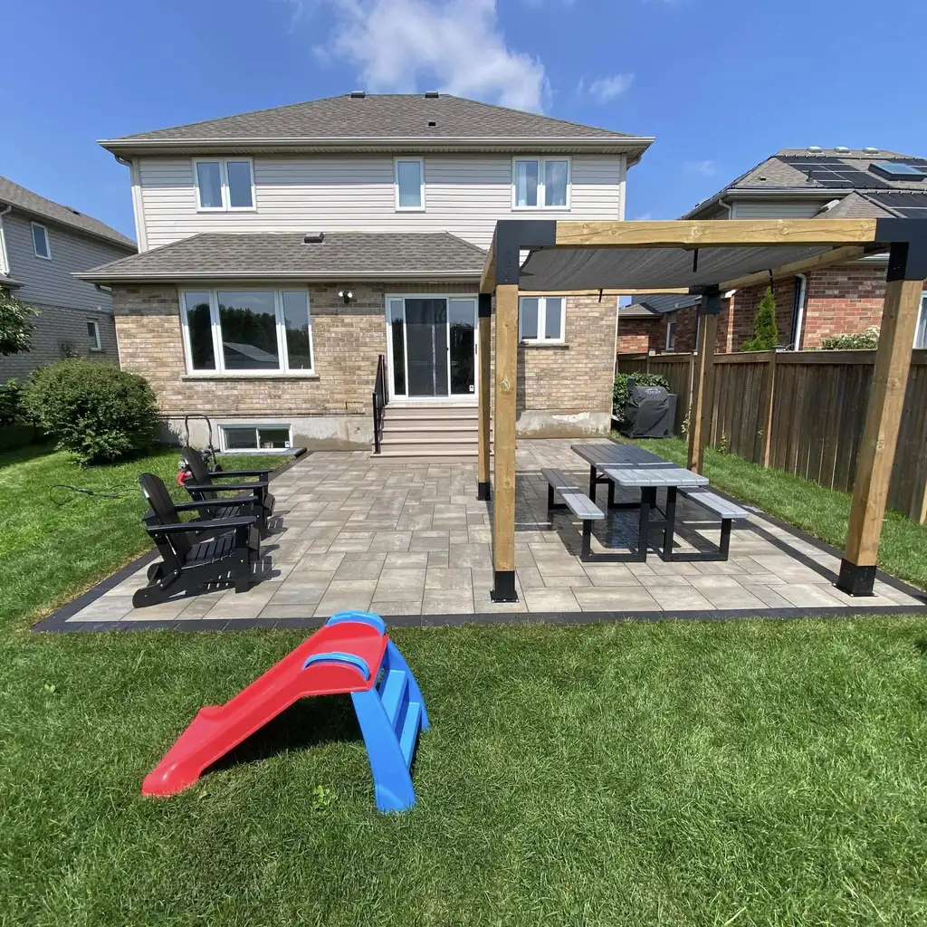 Backyard paver patio with a wood pergola
