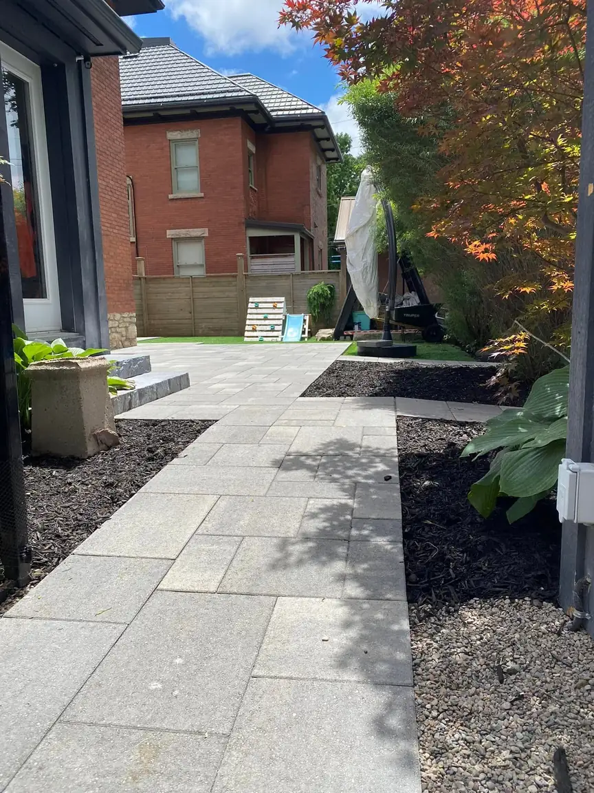 After: clean paver side walkway with fresh garden beds