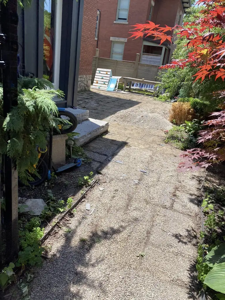 Before: worn gravel side path beside the house
