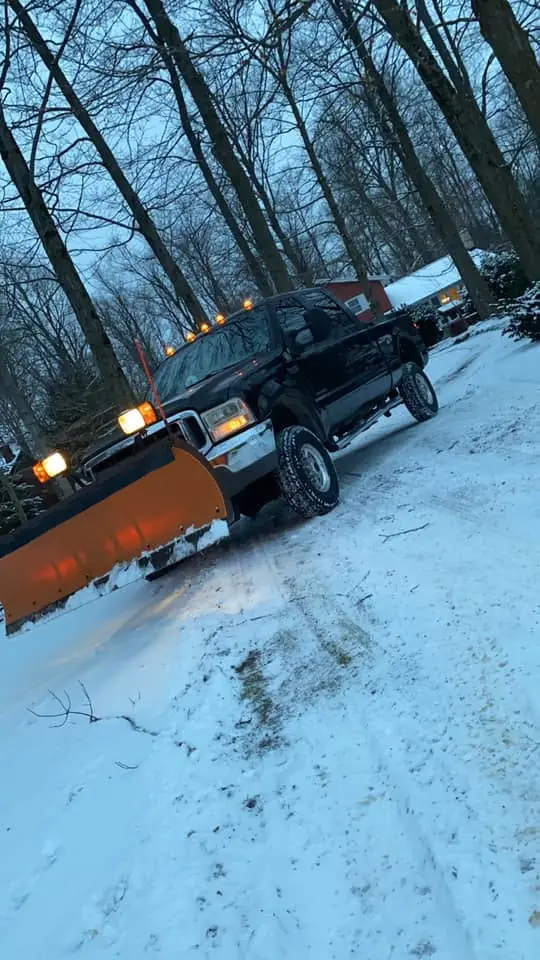 Elevated Landscapes plow truck clearing a snowy driveway